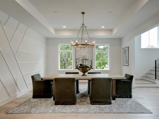 4991 Dumfries Dr, Houston, TX 77096 - dining room featuring a chandelier, light wood-style flooring, stairs, and a tray ceiling