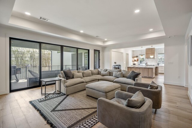 4991 Dumfries Dr, Houston, TX 77096 - living area with a raised ceiling, light wood-style floors, and recessed lighting