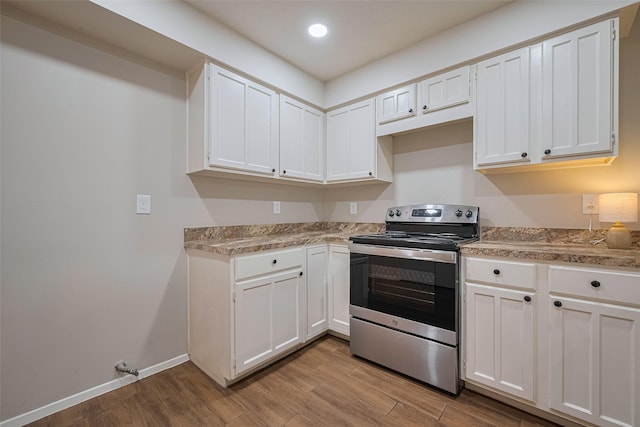 19718 Franz Rd, Houston, TX 77084 - kitchen with electric stove, light wood-style flooring, light countertops, white cabinets, and recessed lighting