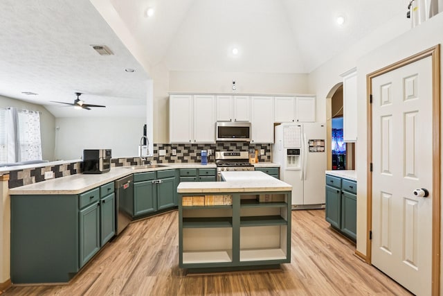 3211 Waterglen Ct, League City, TX 77573 - kitchen featuring green cabinetry, appliances with stainless steel finishes, vaulted ceiling, a peninsula, and a ceiling fan