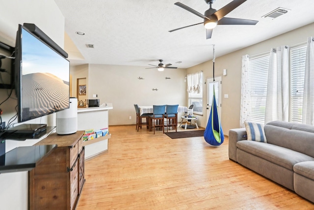 3211 Waterglen Ct, League City, TX 77573 - living area with a ceiling fan, light wood-type flooring, and a textured ceiling