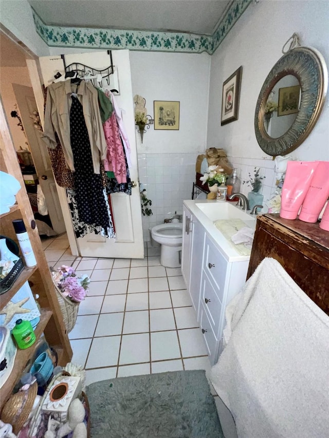 1107 Wooding St, Houston, TX 77011 - bathroom with tile patterned flooring, vanity, a bidet, tile walls, and a wainscoted wall
