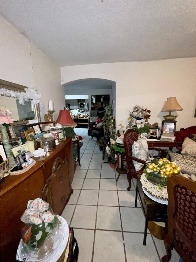 1107 Wooding St, Houston, TX 77011 - dining space with arched walkways, light tile patterned flooring, and a textured ceiling