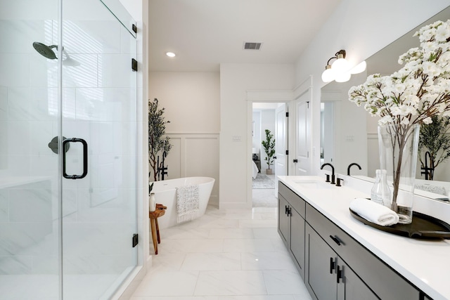 9311 Montridge Dr, Houston, TX 77080 - full bathroom featuring marble finish floors, double vanity, a freestanding bath, a shower stall, and wainscoting