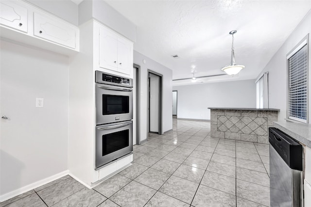 619 Rocky Mountain Dr, Houston, TX 77037 - kitchen featuring stainless steel appliances, white cabinets, light countertops, hanging light fixtures, and light tile patterned floors
