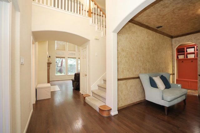 14310 Saint Pierre Ln, Cypress, TX 77429 - entryway featuring dark wood finished floors, arched walkways, ornamental molding, a towering ceiling, and stairs