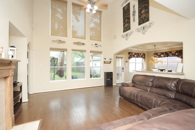 14310 Saint Pierre Ln, Cypress, TX 77429 - living room featuring arched walkways, ceiling fan, wood finished floors, a towering ceiling, and a chandelier