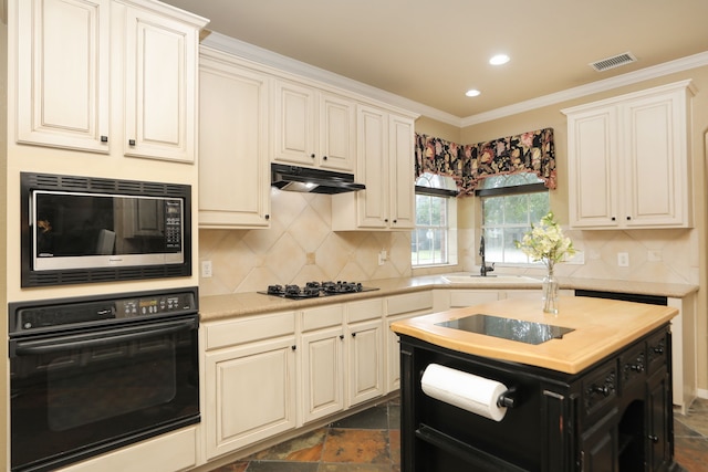 14310 Saint Pierre Ln, Cypress, TX 77429 - kitchen with black appliances, under cabinet range hood, decorative backsplash, stone tile floors, and recessed lighting