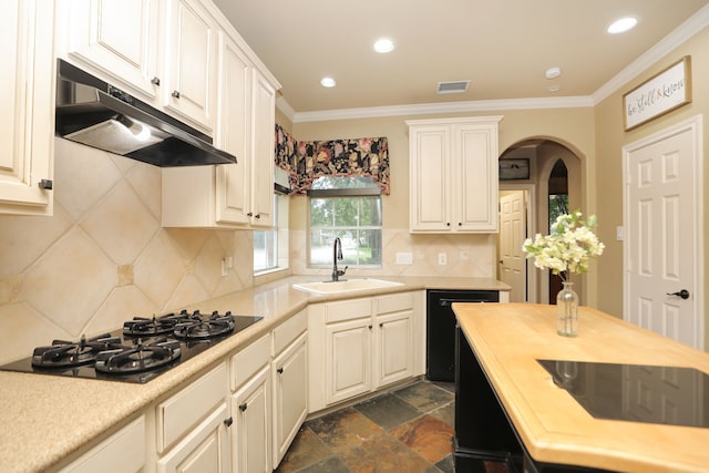 14310 Saint Pierre Ln, Cypress, TX 77429 - kitchen with under cabinet range hood, black appliances, arched walkways, ornamental molding, and recessed lighting
