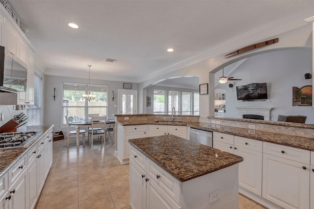 16407 Torry View Ter, Houston, TX 77095 - kitchen with stainless steel appliances, a fireplace, a ceiling fan, arched walkways, and recessed lighting