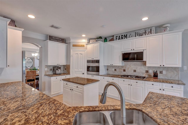 16407 Torry View Ter, Houston, TX 77095 - kitchen featuring appliances with stainless steel finishes, arched walkways, white cabinetry, decorative backsplash, and recessed lighting