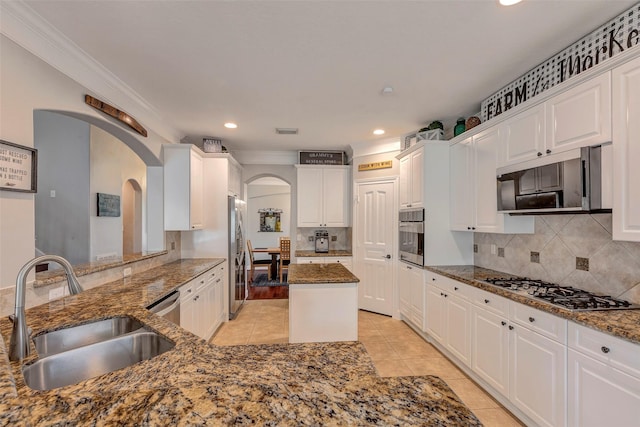 16407 Torry View Ter, Houston, TX 77095 - kitchen featuring arched walkways, appliances with stainless steel finishes, crown molding, light tile patterned floors, and dark stone counters