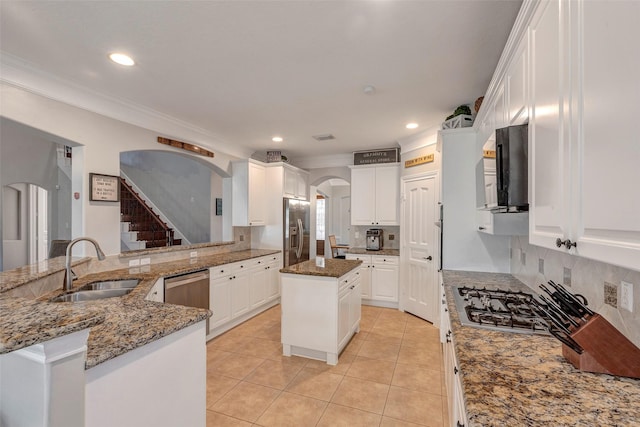 16407 Torry View Ter, Houston, TX 77095 - kitchen featuring arched walkways, appliances with stainless steel finishes, light tile patterned flooring, white cabinetry, and crown molding