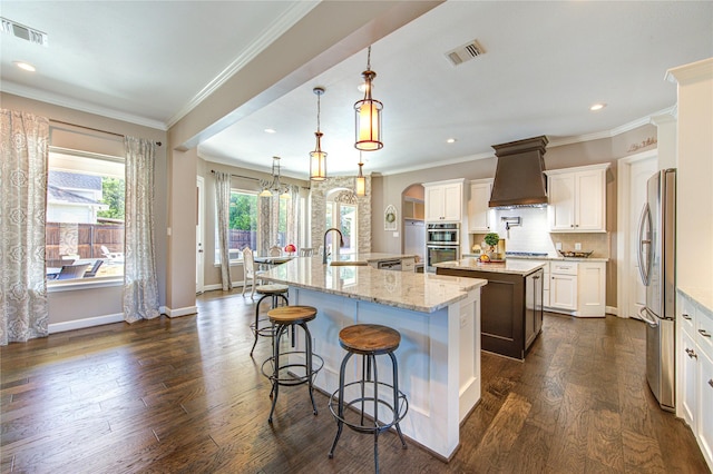 6506 Camillia Ct, Katy, TX 77493 - kitchen with a large island with sink, custom exhaust hood, dark wood finished floors, stainless steel appliances, and recessed lighting
