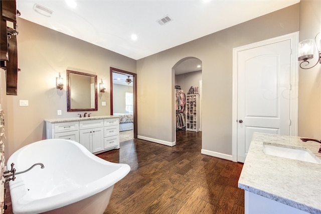 6506 Camillia Ct, Katy, TX 77493 - full bathroom with two vanities, wood finished floors, a freestanding tub, and recessed lighting