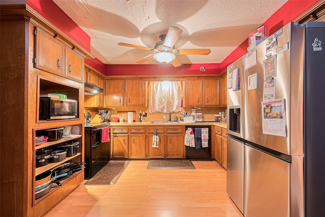 16318 Spinnaker Dr, Crosby, TX 77532 - kitchen with black appliances, brown cabinetry, light countertops, light wood-style flooring, and a textured ceiling