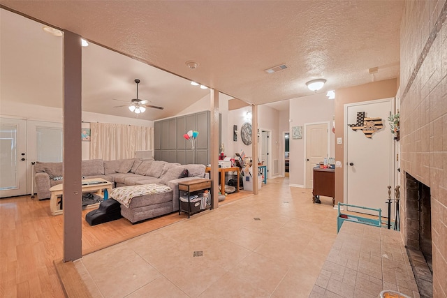 16318 Spinnaker Dr, Crosby, TX 77532 - living room with a textured ceiling, a ceiling fan, a fireplace, and light tile patterned flooring
