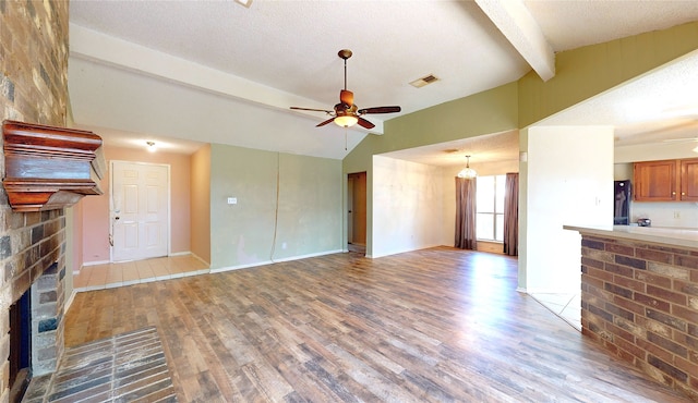 1116 N Bristol Ct, League City, TX 77573 - unfurnished living room featuring a fireplace, wood finished floors, ceiling fan, and a textured ceiling