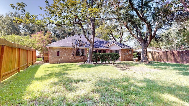 1116 N Bristol Ct, League City, TX 77573 - rear view of house featuring a fenced backyard, brick siding, and roof with shingles