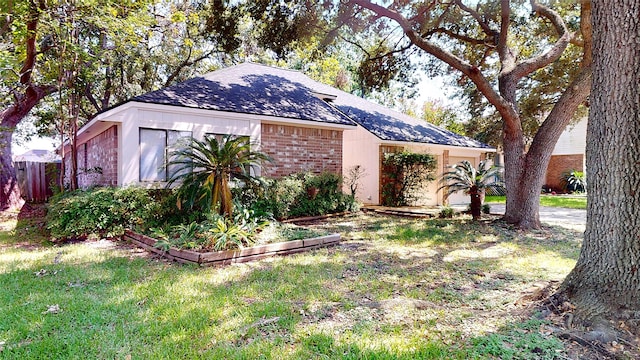 1116 N Bristol Ct, League City, TX 77573 - view of front facade with brick siding, a shingled roof, and a vegetable garden