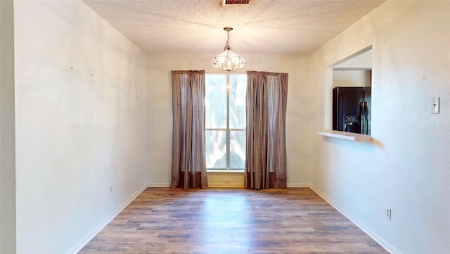 1116 N Bristol Ct, League City, TX 77573 - spare room featuring a chandelier, wood finished floors, and a textured ceiling