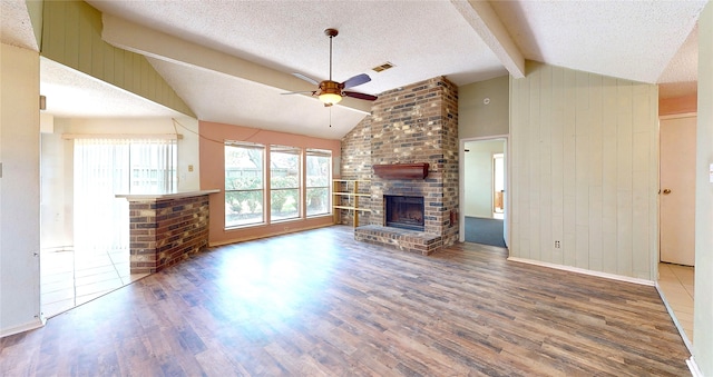 1116 N Bristol Ct, League City, TX 77573 - unfurnished living room featuring a ceiling fan, wood finished floors, a textured ceiling, a fireplace, and wooden walls