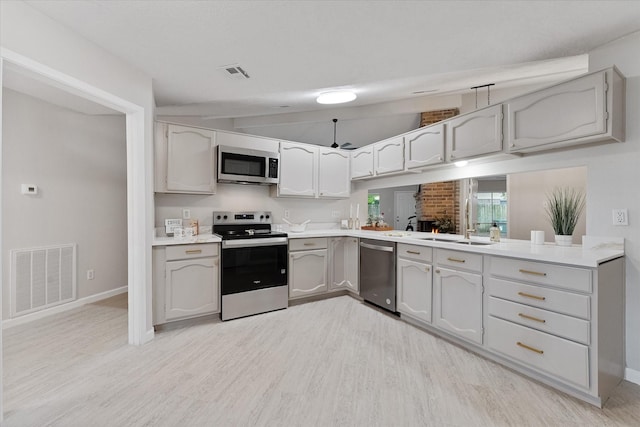 4519 Pineville Ln, Spring, TX 77388 - kitchen with stainless steel appliances, light wood-style flooring, gray cabinetry, and light countertops