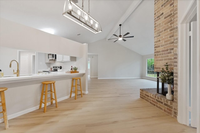 4519 Pineville Ln, Spring, TX 77388 - kitchen featuring appliances with stainless steel finishes, ceiling fan, light wood-style flooring, a kitchen bar, and light countertops