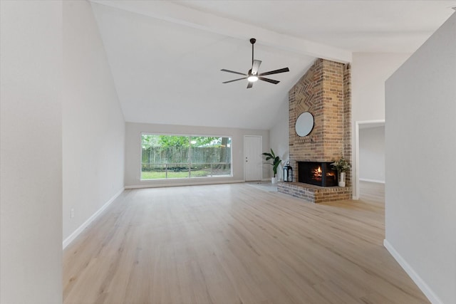 4519 Pineville Ln, Spring, TX 77388 - unfurnished living room featuring wood finished floors, ceiling fan, beamed ceiling, a brick fireplace, and high vaulted ceiling