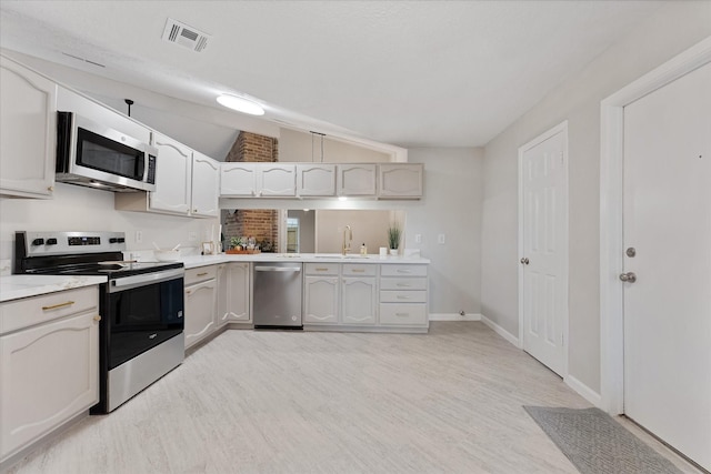 4519 Pineville Ln, Spring, TX 77388 - kitchen featuring stainless steel appliances, lofted ceiling, light wood finished floors, and light countertops