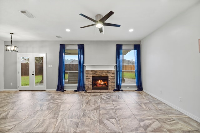 8207 Miramar Crest Ct, Tomball, TX 77375 - unfurnished living room featuring a ceiling fan, a stone fireplace, french doors, recessed lighting, and marble finish flooring