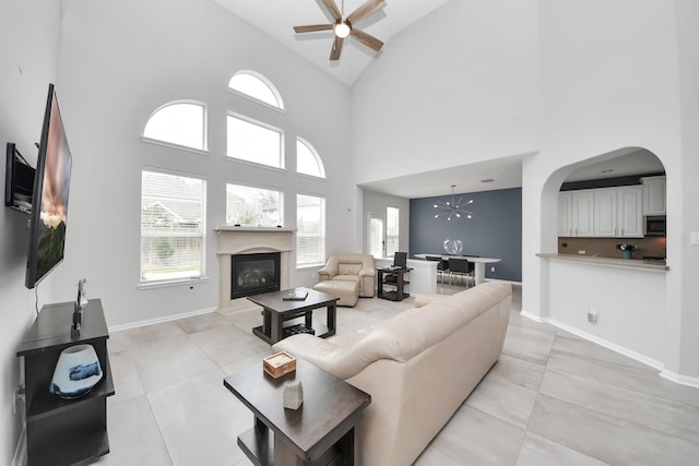13710 Breezy Meadow Ct, Houston, TX 77044 - living room with a ceiling fan, high vaulted ceiling, a glass covered fireplace, arched walkways, and light tile patterned floors