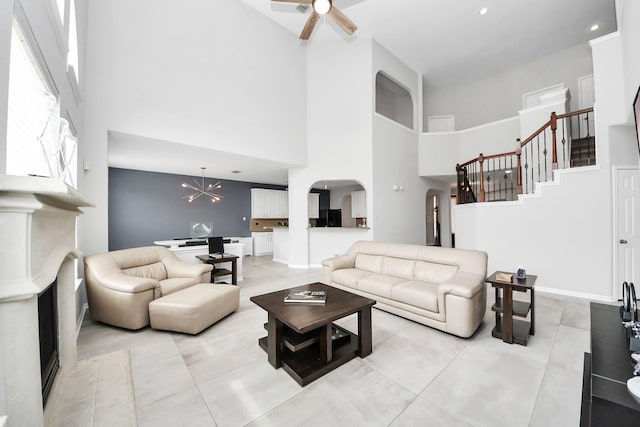 13710 Breezy Meadow Ct, Houston, TX 77044 - living area featuring a towering ceiling, arched walkways, ceiling fan, stairway, and light tile patterned floors