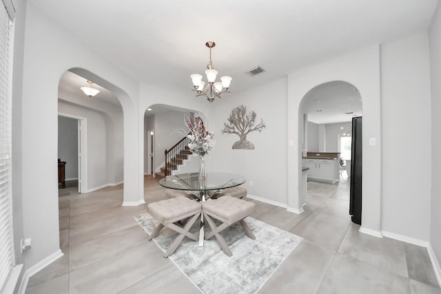 13710 Breezy Meadow Ct, Houston, TX 77044 - dining room with arched walkways, a chandelier, finished concrete floors, and stairway