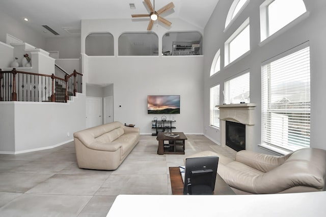 13710 Breezy Meadow Ct, Houston, TX 77044 - living room featuring high vaulted ceiling, a ceiling fan, a glass covered fireplace, and stairway
