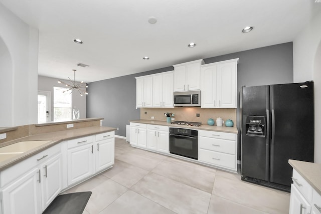 13710 Breezy Meadow Ct, Houston, TX 77044 - kitchen with black appliances, a chandelier, decorative backsplash, light countertops, and white cabinets