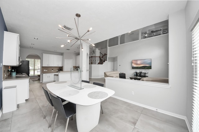 13710 Breezy Meadow Ct, Houston, TX 77044 - dining area featuring a chandelier, arched walkways, healthy amount of natural light, and light tile patterned floors