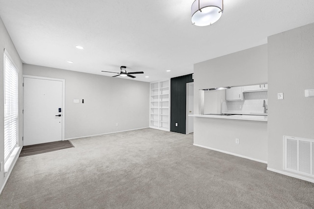 6410 Del Monte Dr Unit 93, Houston, TX 77057 - unfurnished living room featuring ceiling fan, light carpet, built in features, and recessed lighting