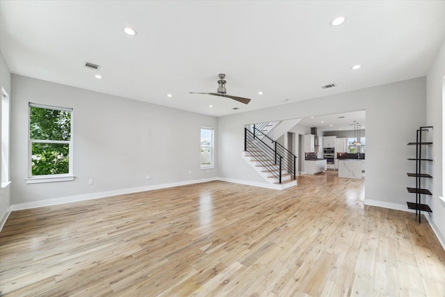 919 W 16th St Unit C, Houston, TX 77008 - unfurnished living room featuring stairs, plenty of natural light, light wood finished floors, a ceiling fan, and recessed lighting