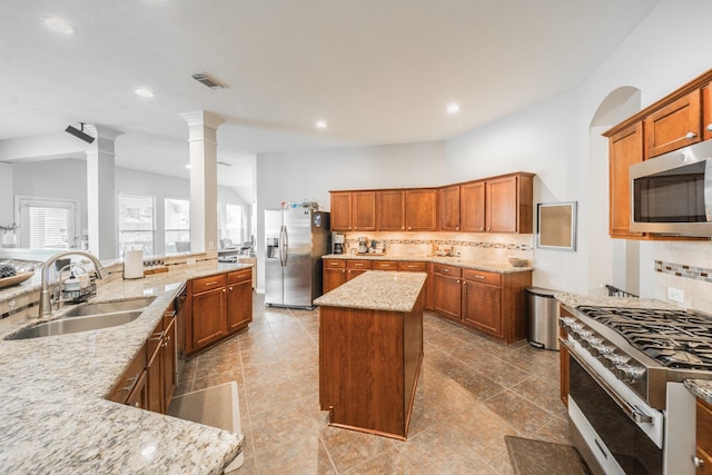 18403 Sierra Falls Ct, Tomball, TX 77377 - kitchen featuring appliances with stainless steel finishes, a center island, backsplash, light stone counters, and recessed lighting