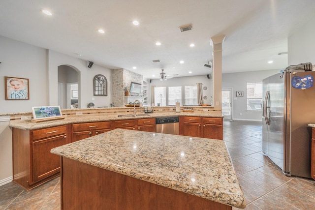 18403 Sierra Falls Ct, Tomball, TX 77377 - kitchen featuring stainless steel appliances, a large island, a ceiling fan, arched walkways, and plenty of natural light