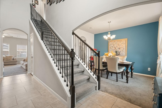 4738 Alluvial Cir, Alvin, TX 77511 - stairway with arched walkways, carpet, tile patterned flooring, and a chandelier