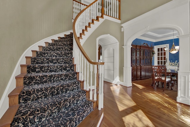 13714 Gainesway Dr, Cypress, TX 77429 - stairs with a high ceiling, wood finished floors, arched walkways, crown molding, and a decorative wall