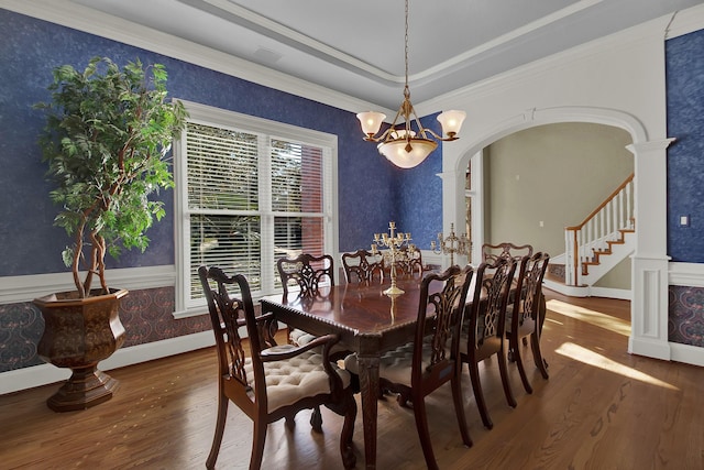 13714 Gainesway Dr, Cypress, TX 77429 - dining room featuring wood finished floors, a chandelier, crown molding, arched walkways, and stairs