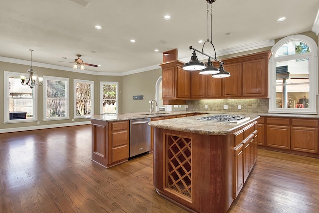 13714 Gainesway Dr, Cypress, TX 77429 - kitchen featuring stainless steel appliances, a kitchen island, ornamental molding, ceiling fan, and decorative backsplash