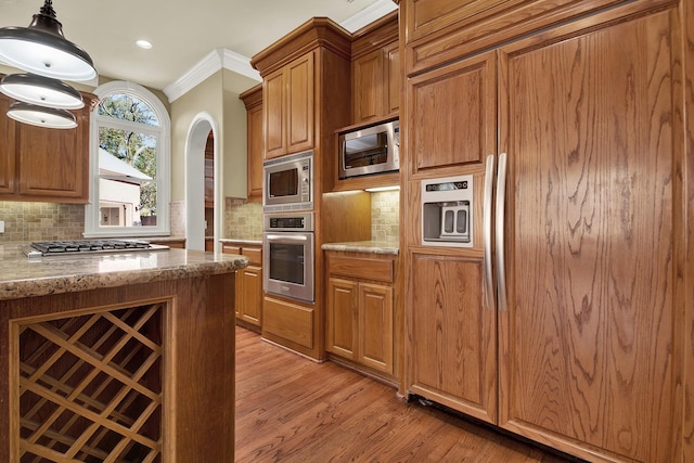 13714 Gainesway Dr, Cypress, TX 77429 - kitchen with built in appliances, light wood-type flooring, crown molding, tasteful backsplash, and light stone counters