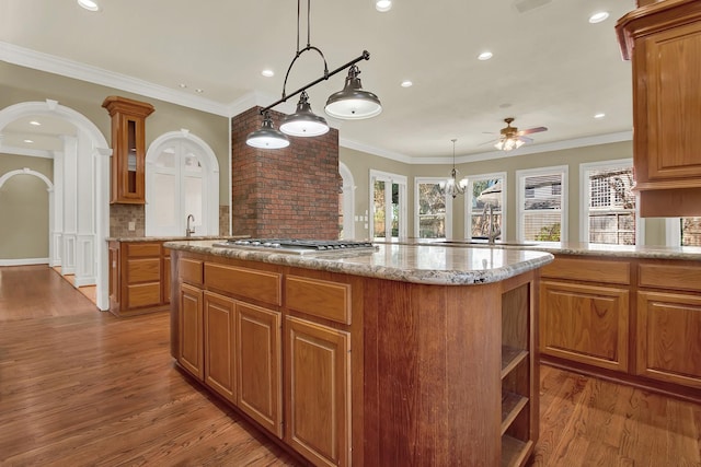 13714 Gainesway Dr, Cypress, TX 77429 - kitchen featuring a center island, wood finished floors, light stone countertops, backsplash, and recessed lighting
