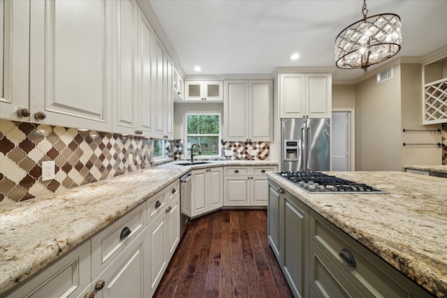 13307 Oddom Ct, Cypress, TX 77429 - kitchen featuring appliances with stainless steel finishes, light stone counters, dark wood finished floors, white cabinetry, and tasteful backsplash