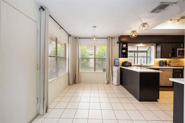 3618 Coltwood Dr, Spring, TX 77388 - kitchen featuring appliances with stainless steel finishes, light countertops, light tile patterned floors, a peninsula, and pendant lighting