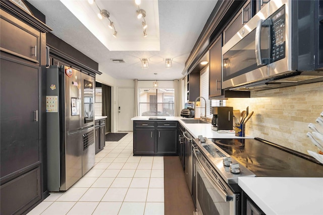 3618 Coltwood Dr, Spring, TX 77388 - kitchen with stainless steel appliances, decorative backsplash, light tile patterned flooring, a raised ceiling, and light countertops